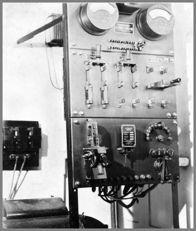 Big open rack with two large meters at the top and a number of knife switches and other gear below