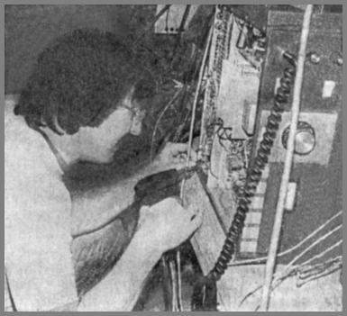 Newspaper photo of Frank Deedrick repairing a radio