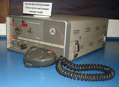 Table top unit 15 inches square and 6 inches hich with front speaker, 2 missing knobs and microphone in front