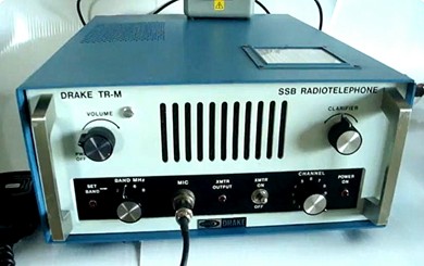 Desk top HF SSB transceiver with 4 knobs, 3 indicator lights, one toggle switch, microphone jack and front mount speaker.