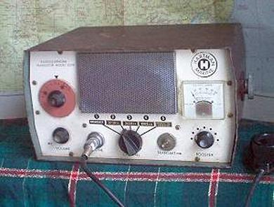 Tabletop Radio transceiver with a rectangular speaker grill in the center, 5 knobs, S meter on right front.