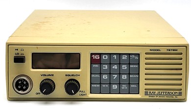 Small VHF FM unit with 2 knobs, keypad, channel? indicator window, microphone jack and front mount speaker.