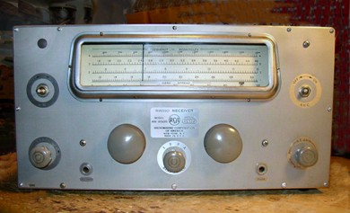 Shock-mounted radio receiver with 3 knobs, 2 tuning knobs and a slide-rule dial