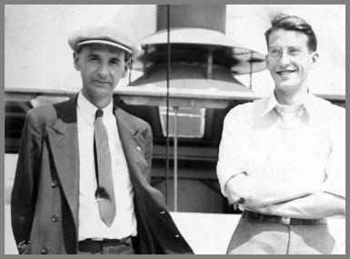 Two radio operators on deck with the bottom of one of the ship's stacks in the background