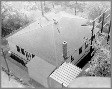 Looking down at the roof of the WAY building with telephone poles on the right for transmission line support.