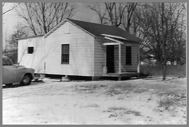 Small white building on concrete blocks - snow on ground